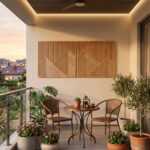 Geometric wood wall art with mountain patterns above a bistro table on a plant-filled balcony
