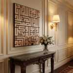 Islamic wall art in geometric Kufic script above a carved console table with flowers and a wall sconce