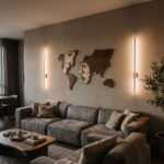 World map wall art with abstract faces above a gray sectional sofa in a modern living room